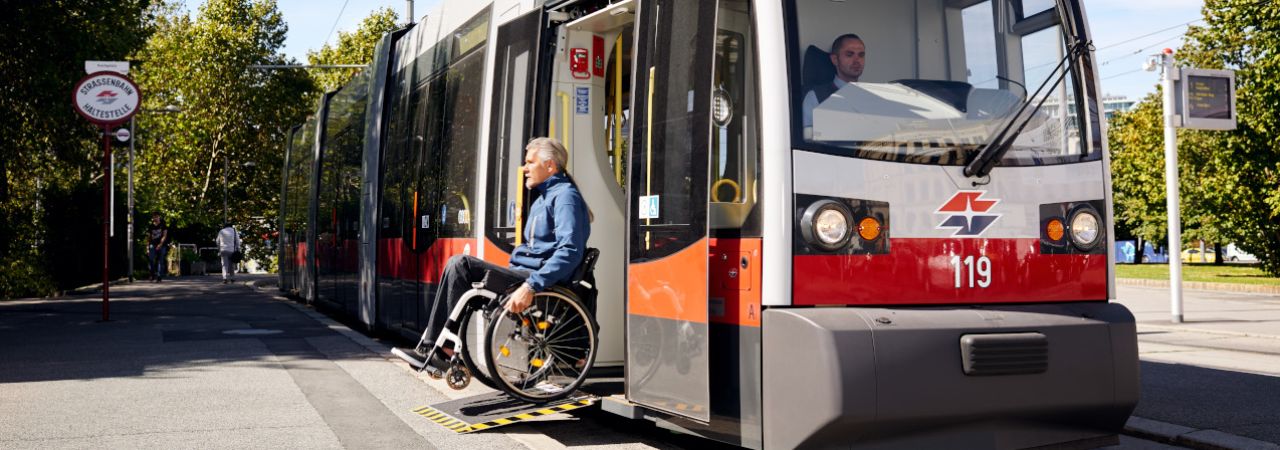 Ein Rollstuhlfahrer verlässt die Straßenbahn auf einer Rampe.