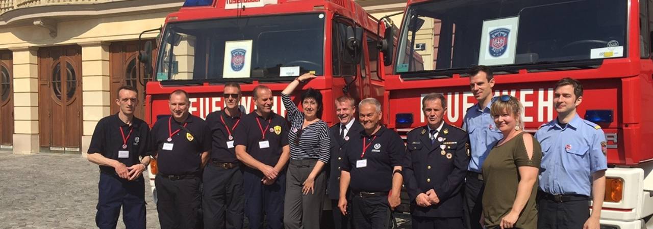 Gruppenbild vor Feuerwehrfahrzeugen